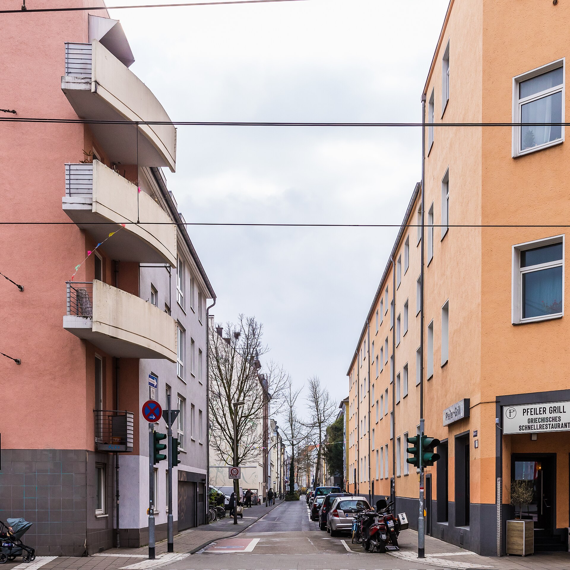 Wohnstraße in Köln-Ehrenfeld mit Mehrfamilienhäusern, Balkonen und einem Ladenlokal im Erdgeschoss