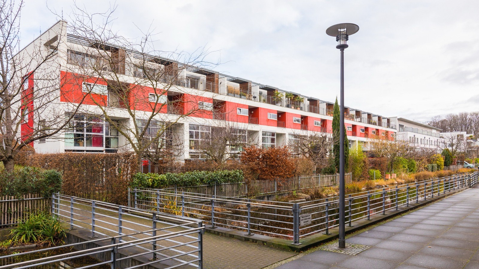 Stadthäuser am Johannes-Theodor-Baargeldweg im Stadtwaldviertel in Köln-Junkersdorf mit Terrassen und Gärten an einem Wasserlauf