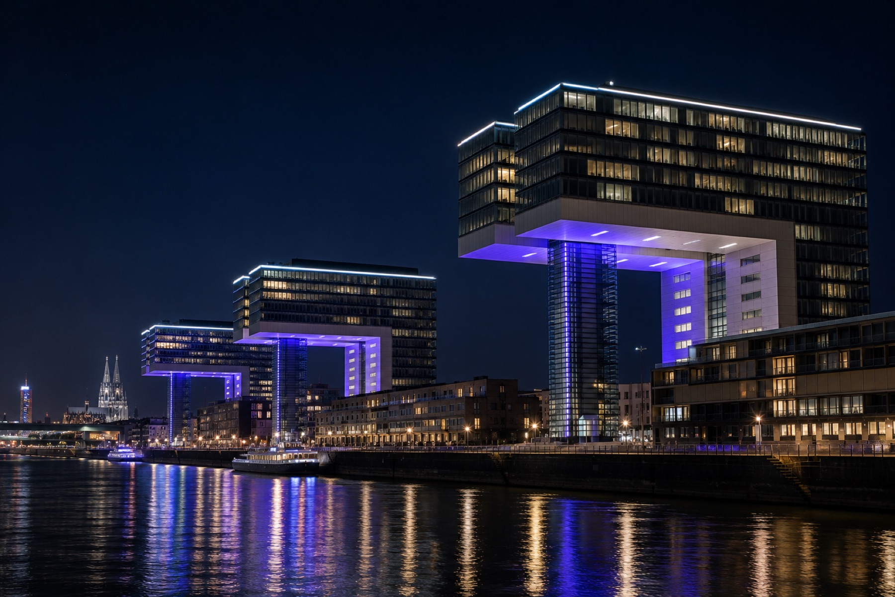 Kranhäuser im Kölner Rheinauhafen bei Nacht mit Dom im Hintergrund. Standort von Highseller Immobilien
