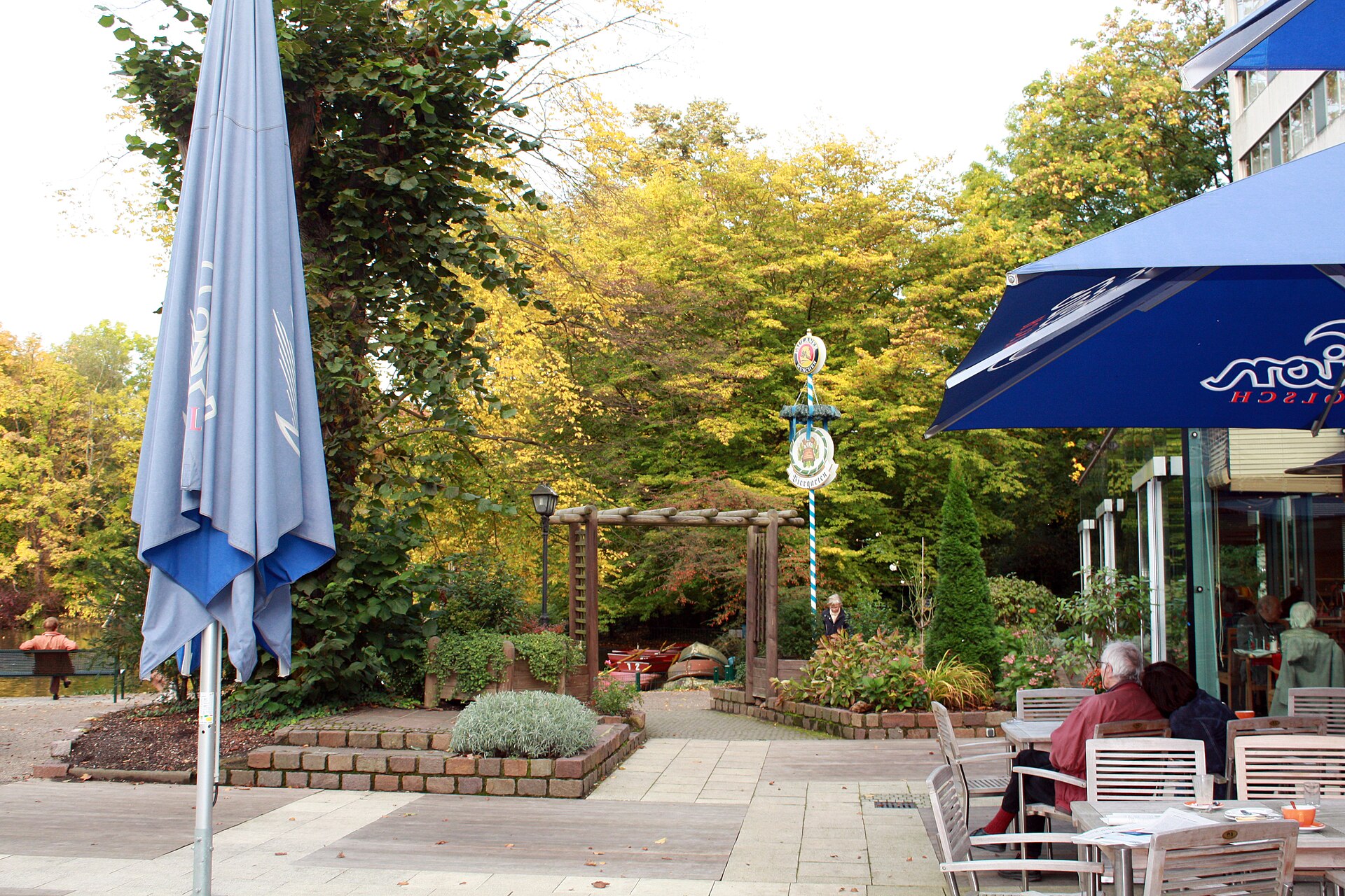 Terrasse am Weiher im Kölner Stadtwald mit altem Baumbestand