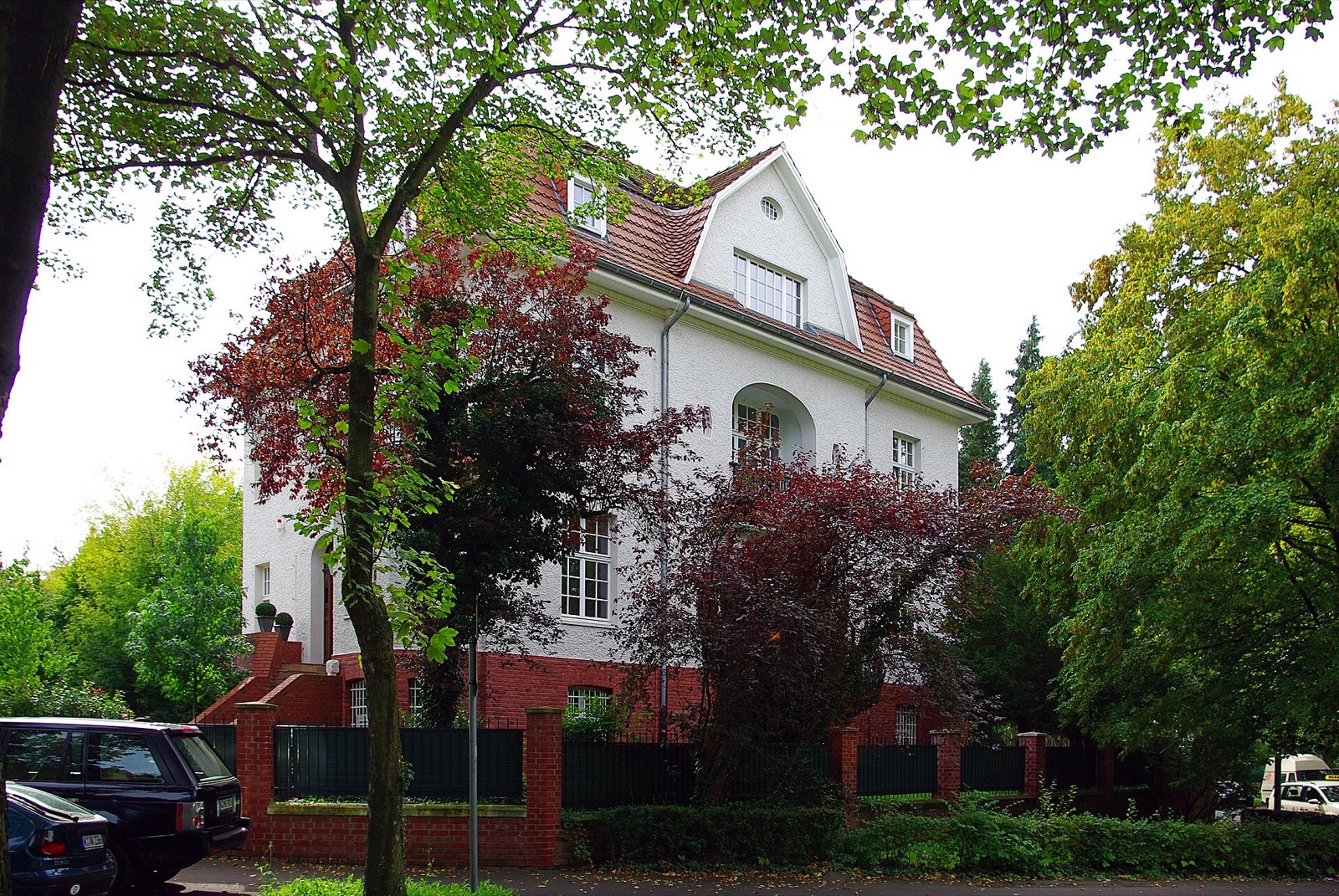 Villa an der Straße Unter den Ulmen in Köln-Marienburg mit rotem Ziegeldach und Rundbogenloggia