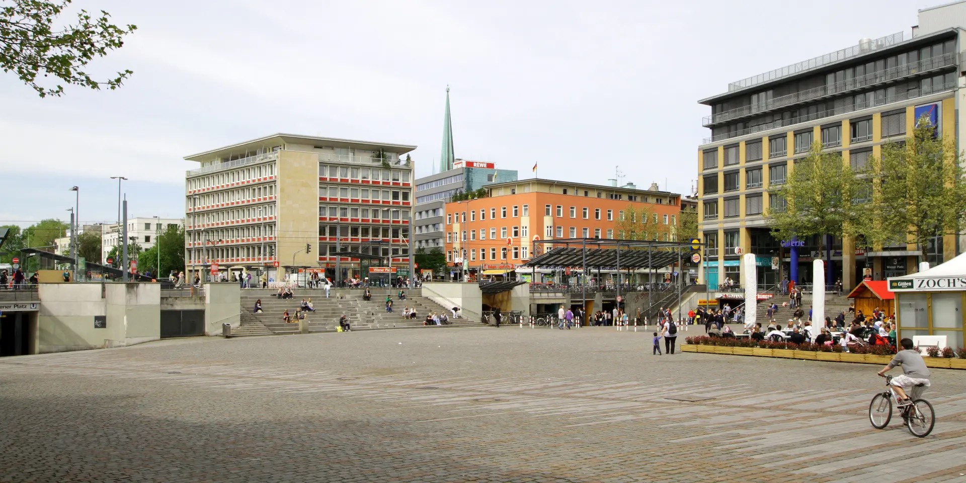 Der Wiener Platz in Köln-Mülheim mit Sitzstufen, Außengastronomie und der umgebenden Bebauung