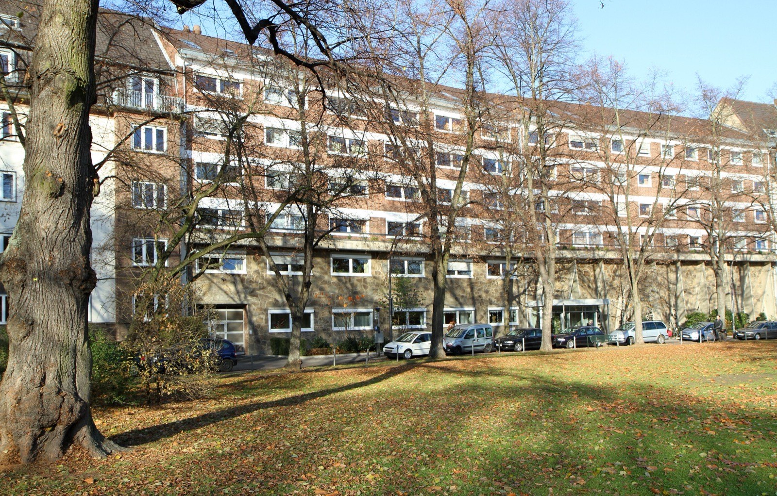 Wohnzeile der Nachkriegsjahre am Oberländer Wall in Köln-Neustadt-Süd, davor eine Grünfläche mit alten Bäumen