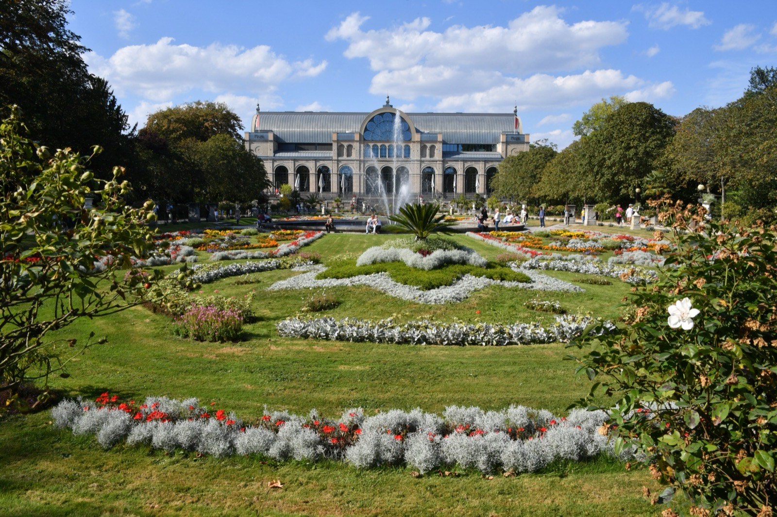Die Flora in Köln-Riehl mit Blumenbeeten, Springbrunnen und dem historischen Festhaus